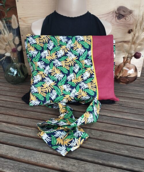 tablier Bouillotte Nonno Toucan, avec des motifs feuillus verts, jaunes et blancs avec une section marron unie.